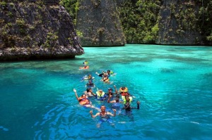 Para wisatawan menikmati kesegaran dan kejernihan air laut Raja Ampat. 
